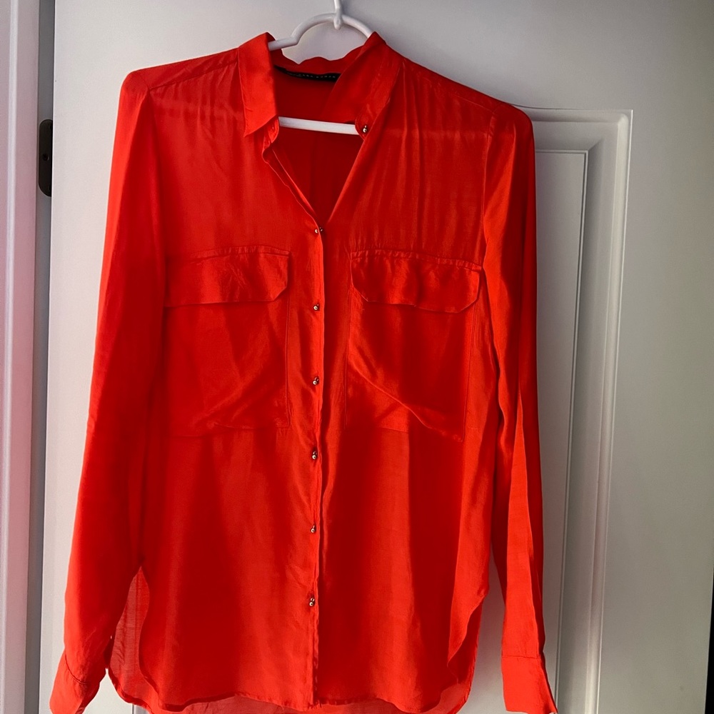 Orange blouse with tiny gold round buttons